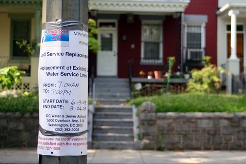 A lead service replacement notice taped to a pole in front of row houses in Washington, D.C.